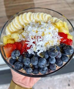 Carrot Express fruit bowl featuring blueberries, strawberries, bananas, and coconut shavings