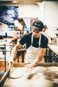 Frank Pepe Pizzeria chef preparing dough for a pizza