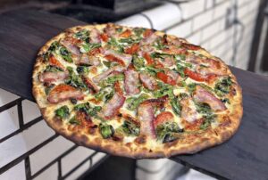 Frank Pepe’s Special pizza with spinach, tomato, and bacon