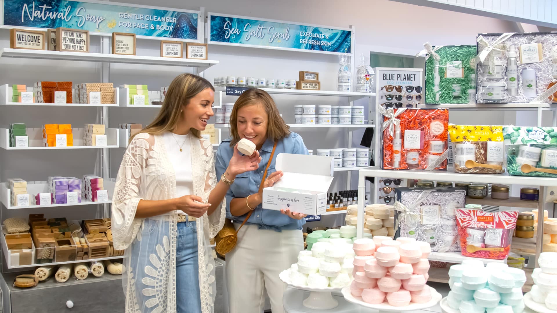 Two women sampling scented soap bars at Naples Soap Company