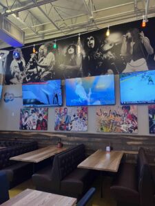 Rock & Brews dining booths with wall-mounted TVs showing various sports and news channels