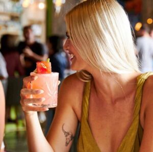 Woman holding a colorful drink at the Tacocraft tequila bar