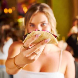 Woman holding a taco from Tacocraft
