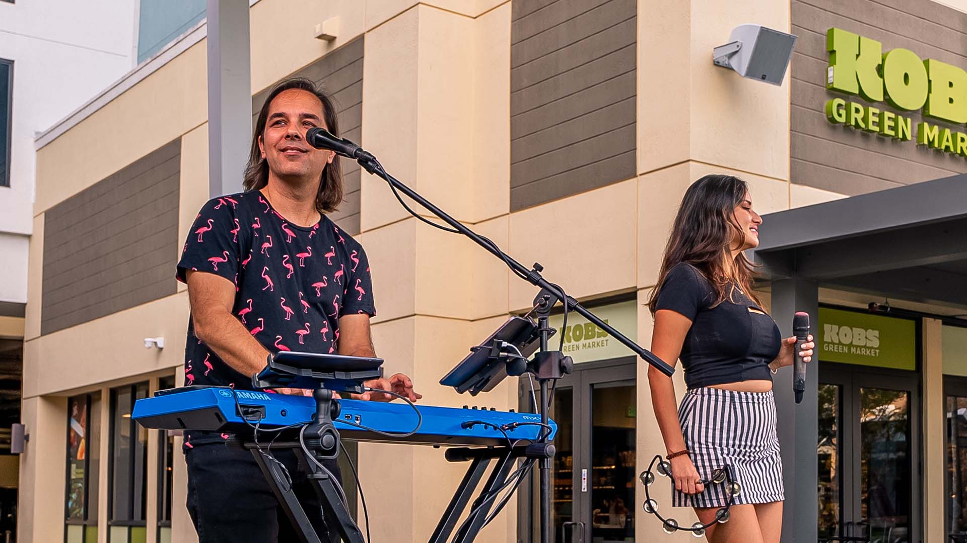 Musician playing guitar live at the Plantation Walk Plaza stage